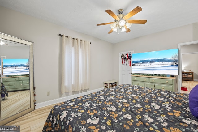 bedroom featuring multiple windows, ceiling fan, and light wood-type flooring