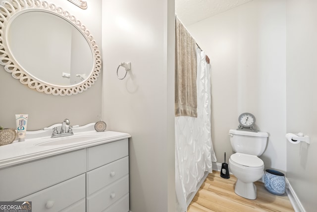 bathroom featuring vanity, toilet, and wood-type flooring