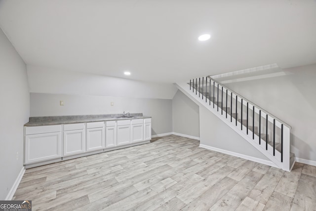 interior space with lofted ceiling, light hardwood / wood-style floors, and sink