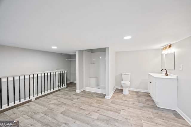 bathroom with vanity, toilet, hardwood / wood-style floors, and a shower