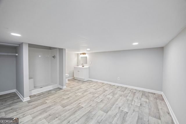 basement featuring sink and light wood-type flooring