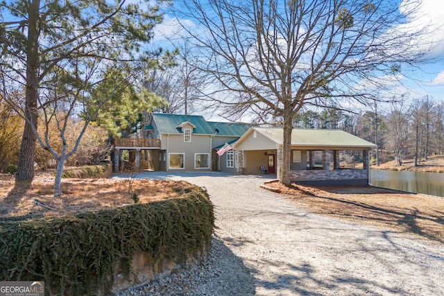 view of front of house with a carport and a water view