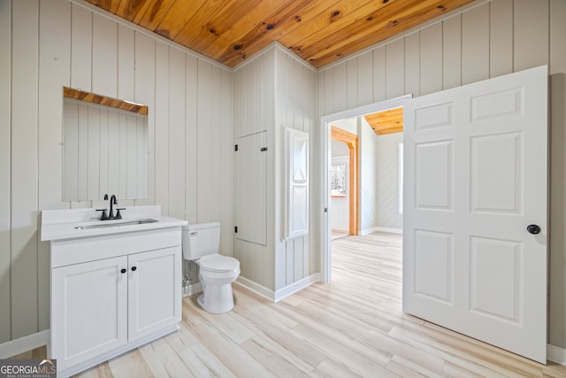 bathroom featuring vanity, wood ceiling, wood-type flooring, and toilet