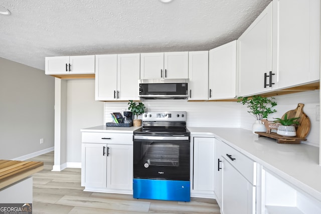 kitchen featuring white cabinetry, light hardwood / wood-style flooring, a textured ceiling, and electric stove