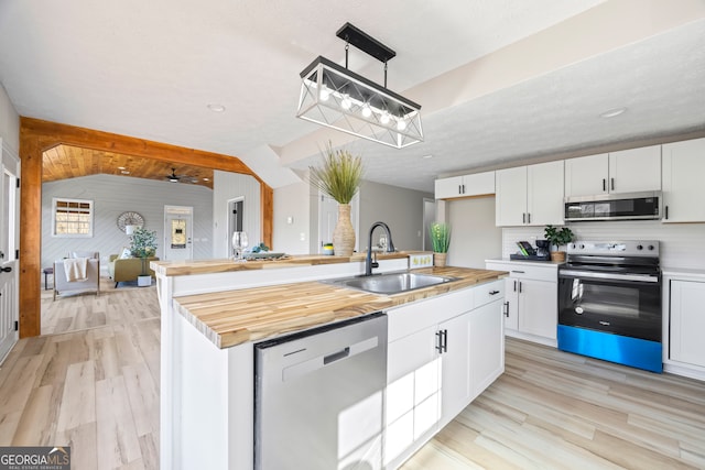 kitchen featuring sink, a kitchen island with sink, stainless steel appliances, white cabinets, and decorative light fixtures