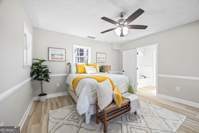 bedroom with ceiling fan, a textured ceiling, and light hardwood / wood-style flooring