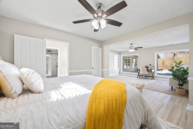 bedroom with connected bathroom, a textured ceiling, light hardwood / wood-style floors, and ceiling fan