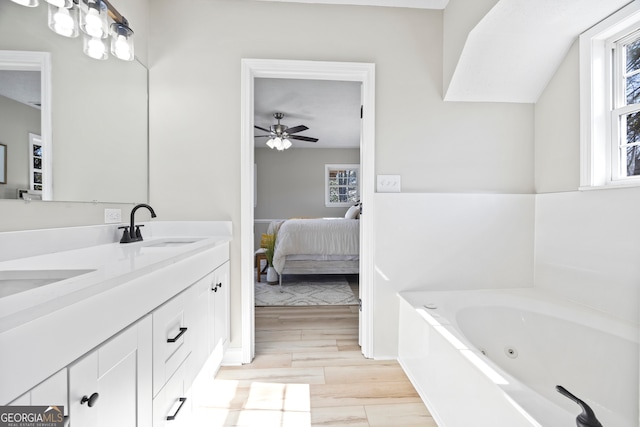 bathroom featuring ceiling fan, a tub to relax in, vanity, and a wealth of natural light