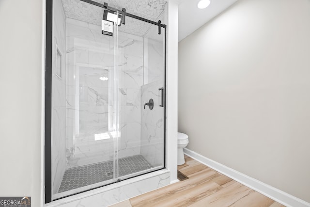 bathroom with an enclosed shower, hardwood / wood-style floors, and toilet