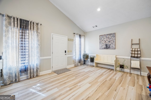 entrance foyer with high vaulted ceiling, plenty of natural light, and light hardwood / wood-style floors