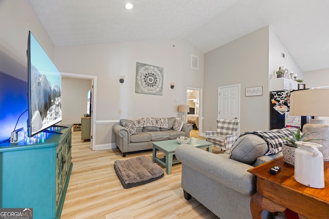 living room featuring high vaulted ceiling and light wood-type flooring