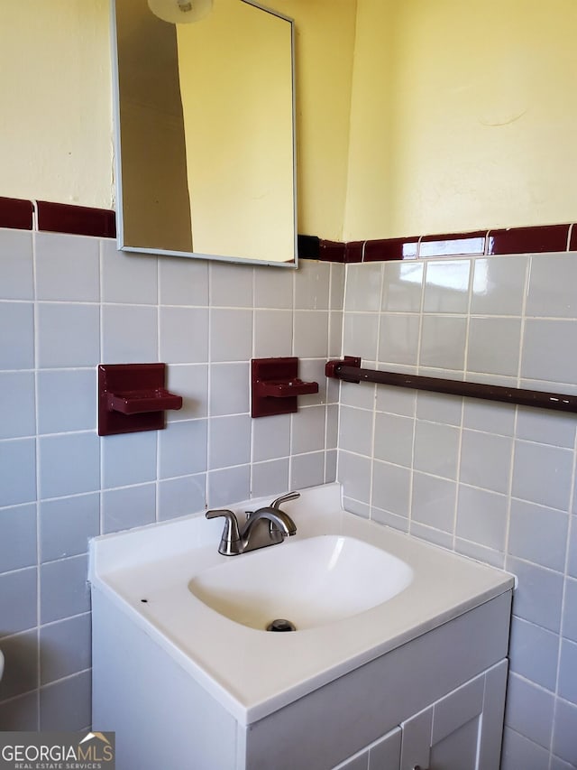 bathroom featuring vanity and tile walls