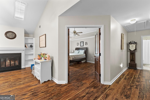 hallway with lofted ceiling and dark wood-type flooring