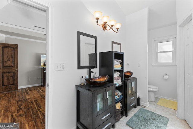 bathroom featuring vanity, toilet, and an inviting chandelier