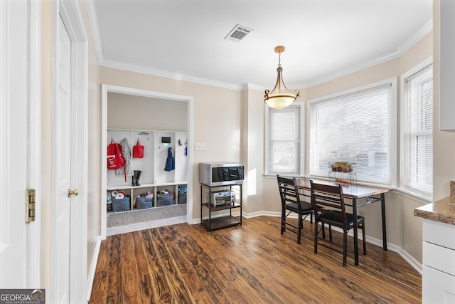 dining area featuring hardwood / wood-style floors and crown molding