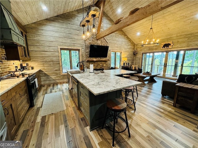 kitchen featuring wood ceiling, light stone counters, pendant lighting, a large island, and black gas range