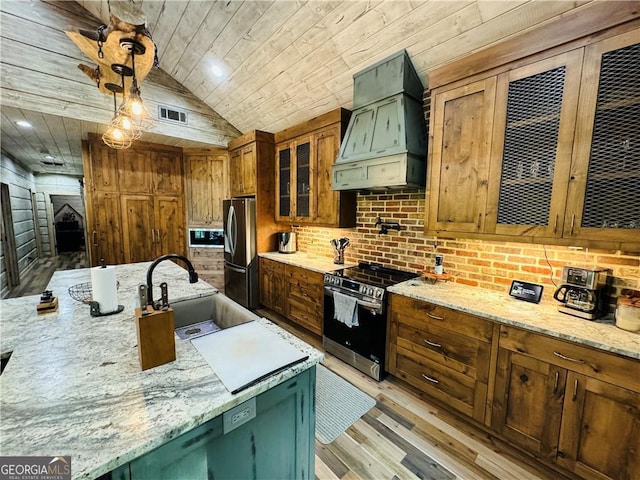 kitchen with pendant lighting, sink, stainless steel appliances, light stone countertops, and custom range hood