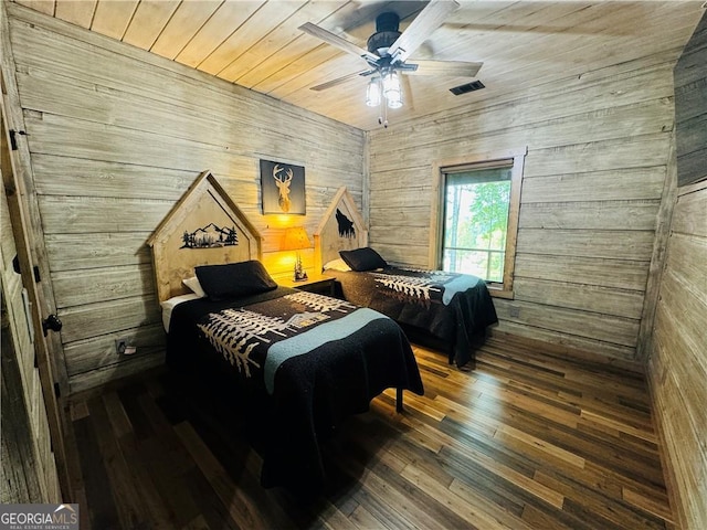 bedroom with dark hardwood / wood-style floors, wooden ceiling, ceiling fan, and wood walls