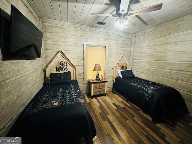 bedroom with ceiling fan, wooden ceiling, wood-type flooring, and wood walls