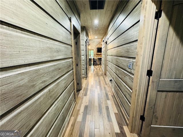 hall featuring wood ceiling, wooden walls, and hardwood / wood-style floors