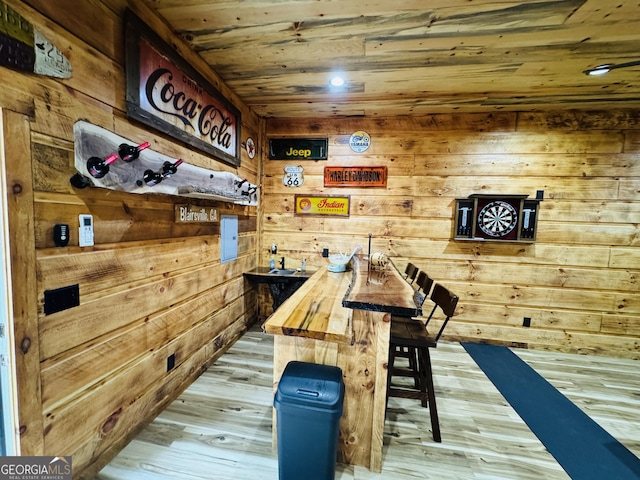 dining space with light hardwood / wood-style flooring, wood ceiling, and wood walls