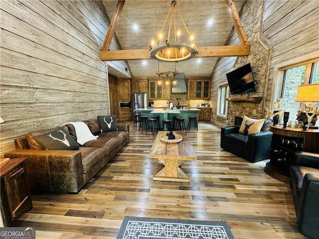 living room featuring beam ceiling, light wood-type flooring, and high vaulted ceiling