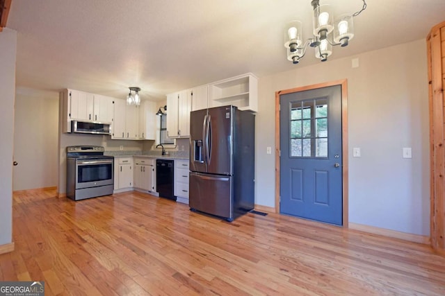 kitchen featuring pendant lighting, white cabinetry, a chandelier, stainless steel appliances, and light wood-type flooring