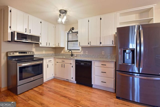 kitchen featuring stainless steel appliances, sink, white cabinets, and light hardwood / wood-style floors