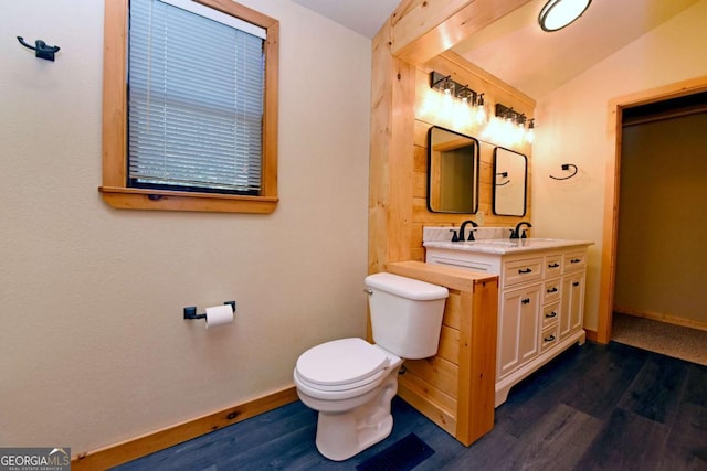 bathroom featuring hardwood / wood-style flooring, vanity, toilet, and vaulted ceiling