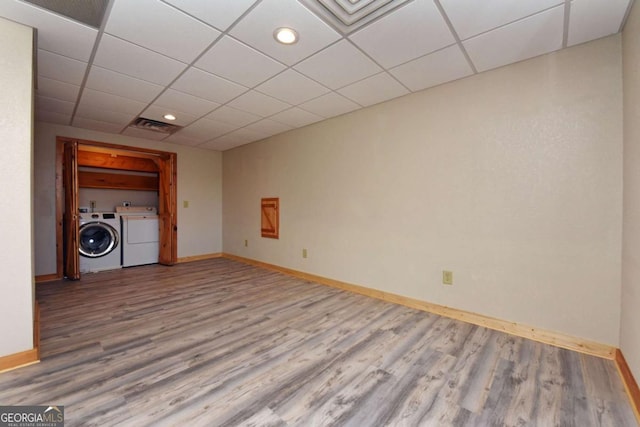 interior space with hardwood / wood-style flooring, washer and clothes dryer, and a drop ceiling