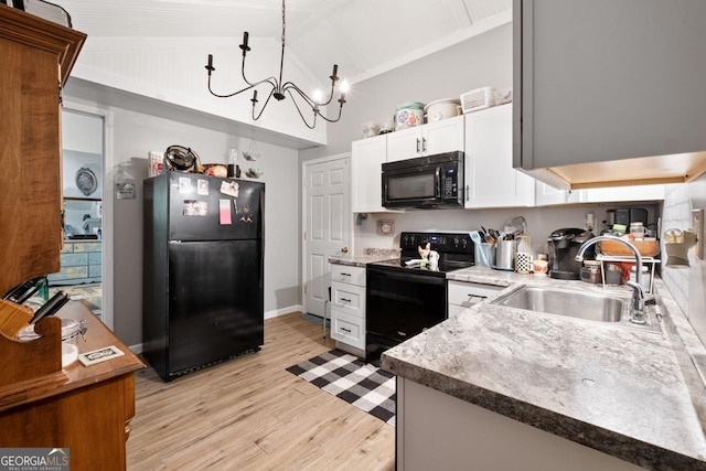 kitchen featuring vaulted ceiling, decorative light fixtures, sink, white cabinets, and black appliances