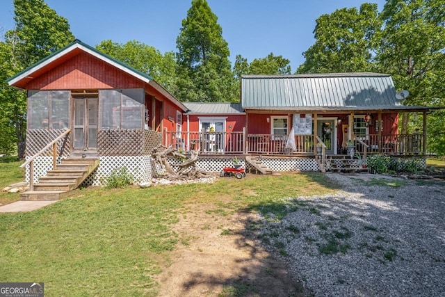 view of front facade with a front lawn and a sunroom