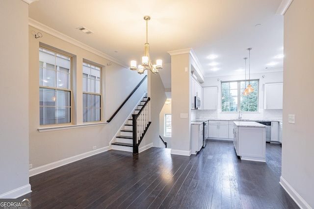 kitchen featuring dark wood-type flooring, hanging light fixtures, a center island, white cabinets, and decorative backsplash