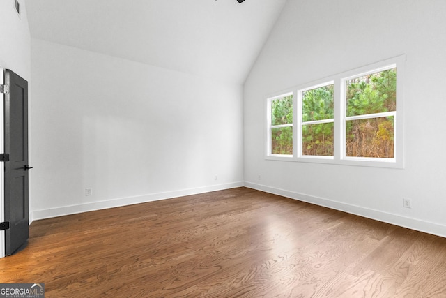 empty room with lofted ceiling and wood-type flooring