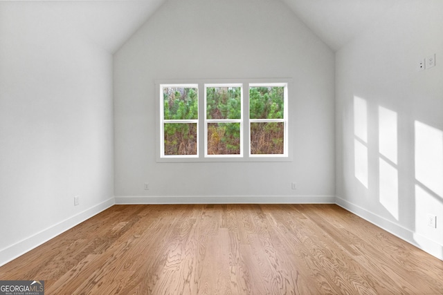 unfurnished room with lofted ceiling and light hardwood / wood-style floors