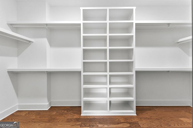 spacious closet with dark hardwood / wood-style flooring