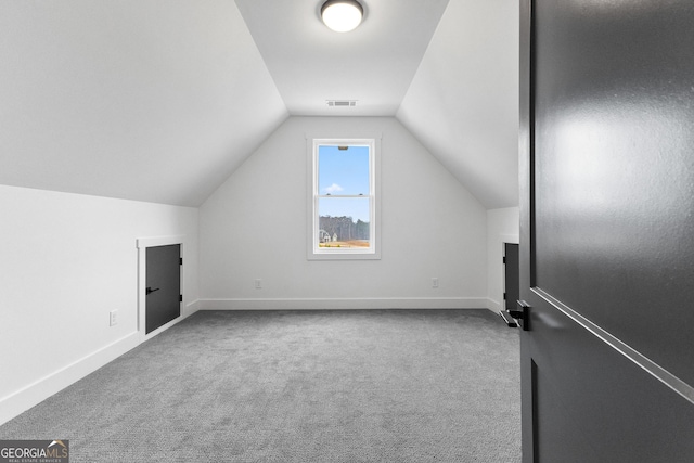 additional living space with carpet flooring and vaulted ceiling