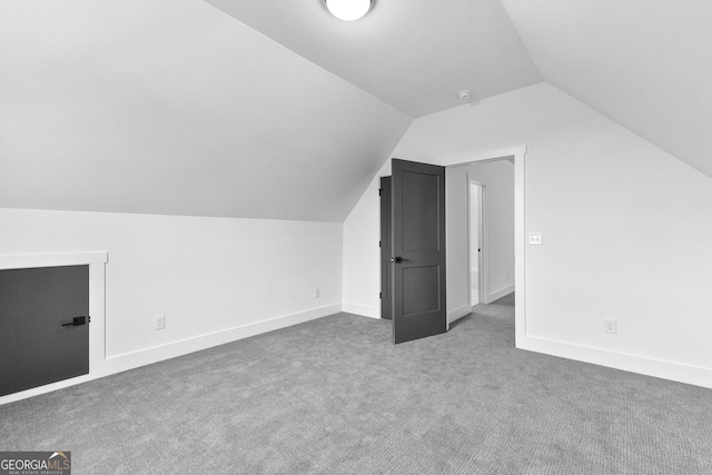 bonus room with vaulted ceiling and carpet