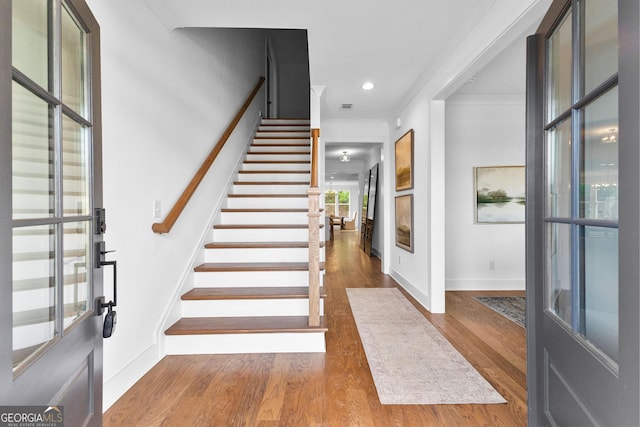 entryway featuring ornamental molding and hardwood / wood-style floors