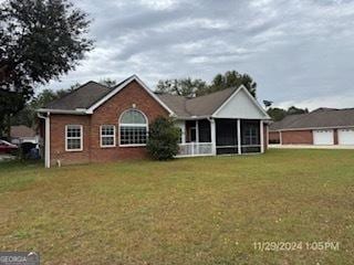 view of front of home featuring a front yard and a sunroom