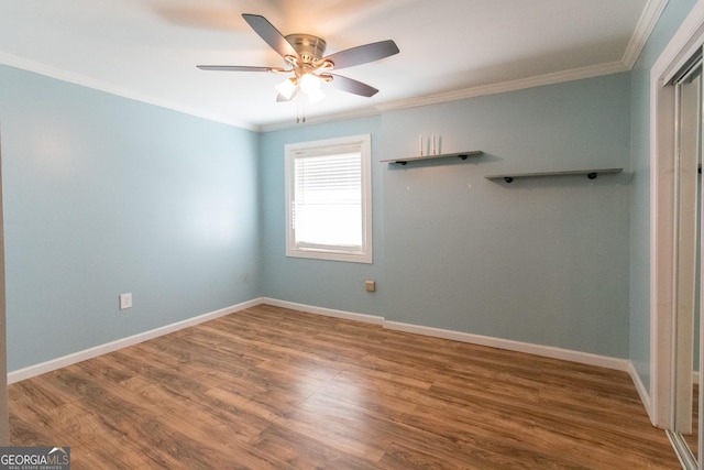 empty room with wood-type flooring, ornamental molding, and ceiling fan