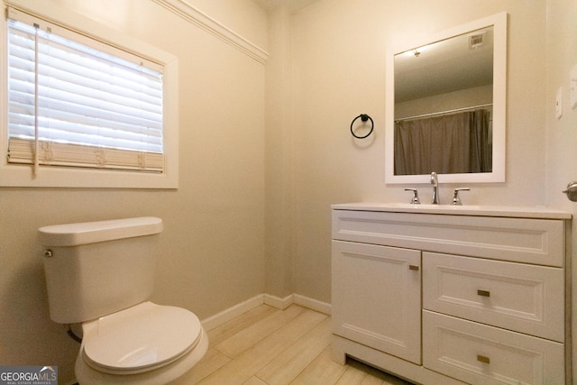 bathroom with hardwood / wood-style flooring, vanity, and toilet