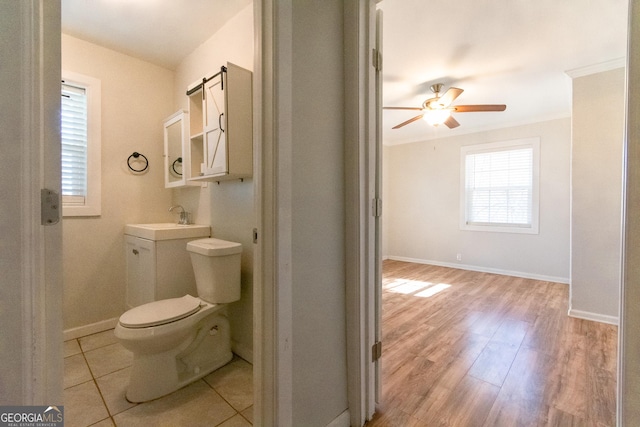 bathroom with toilet, sink, crown molding, ceiling fan, and hardwood / wood-style floors