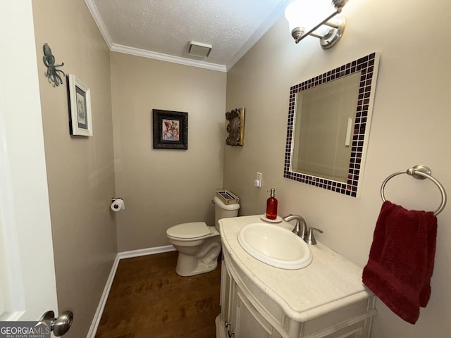 bathroom featuring vanity, crown molding, toilet, and a textured ceiling