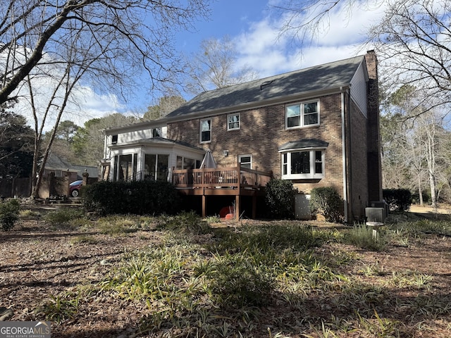 rear view of house featuring a wooden deck, a sunroom, and central AC unit