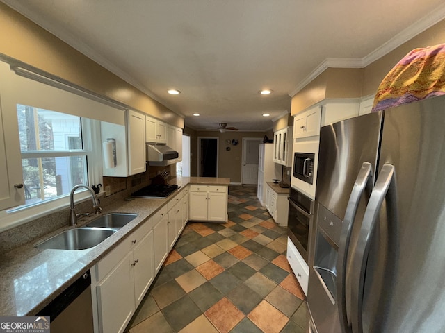 kitchen featuring sink, kitchen peninsula, stainless steel appliances, light stone countertops, and white cabinets