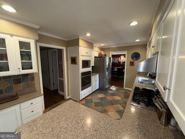 kitchen with sink, crown molding, white cabinetry, stainless steel appliances, and decorative backsplash