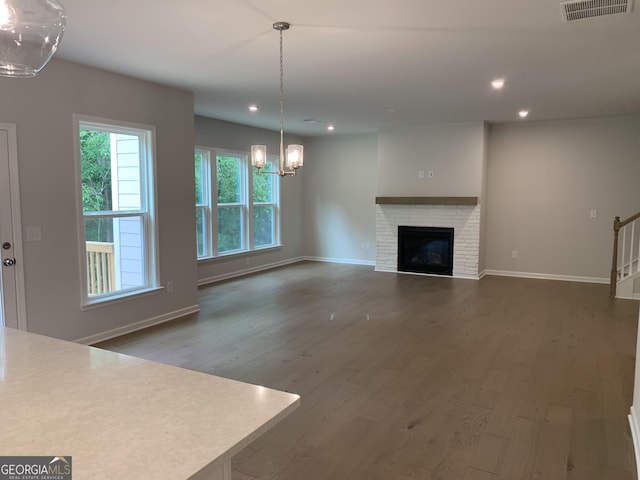 7406 Grand Reunion Dr, Hoschton, GA 30548 - unfurnished living room with a chandelier, wood finished floors, baseboards, recessed lighting, and stairs
