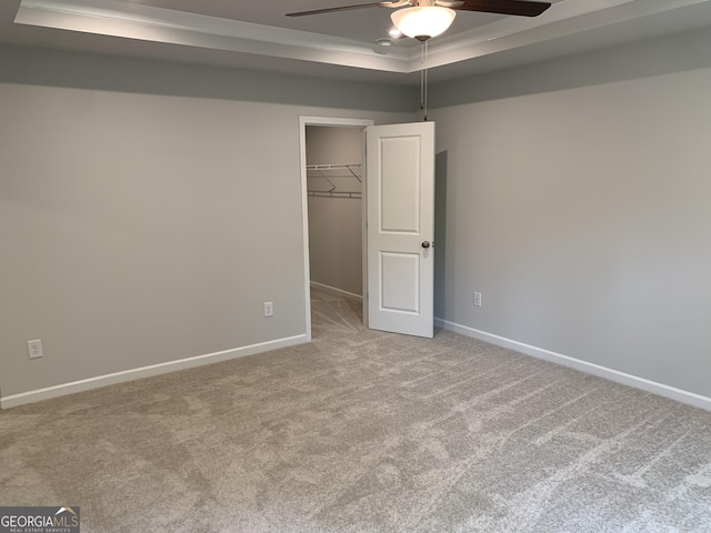 7406 Grand Reunion Dr, Hoschton, GA 30548 - unfurnished bedroom with a tray ceiling, carpet flooring, a spacious closet, and baseboards