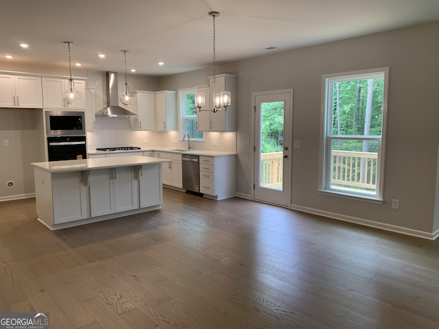 7406 Grand Reunion Dr, Hoschton, GA 30548 - kitchen featuring wall chimney range hood, appliances with stainless steel finishes, a sink, light countertops, and dark wood-style flooring